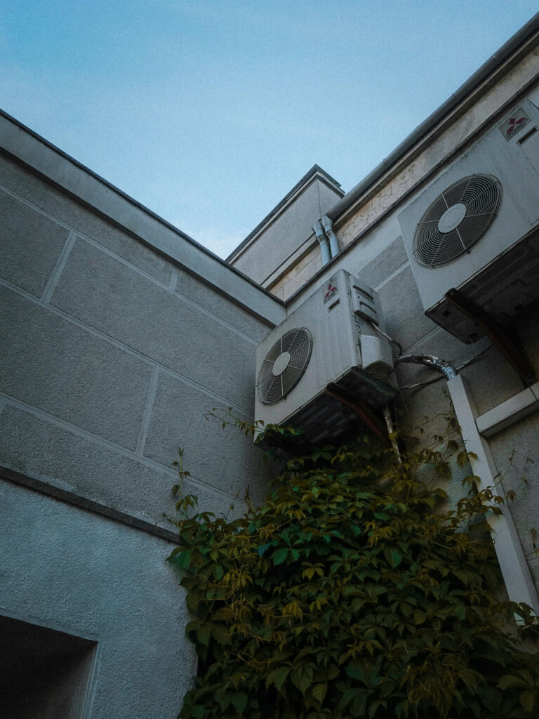 Condenser units of Mitsubishi HVAC systems on the exterior wall of a house