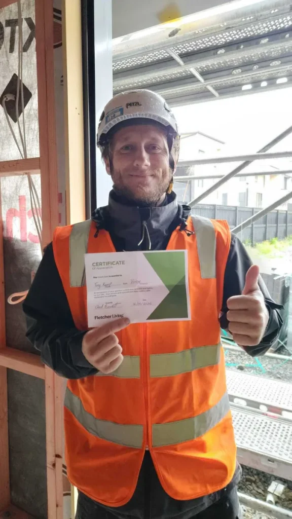 Varcoe technician Tony holding a Certificate of Appreciation for his contribution to health and safety on an Auckland site